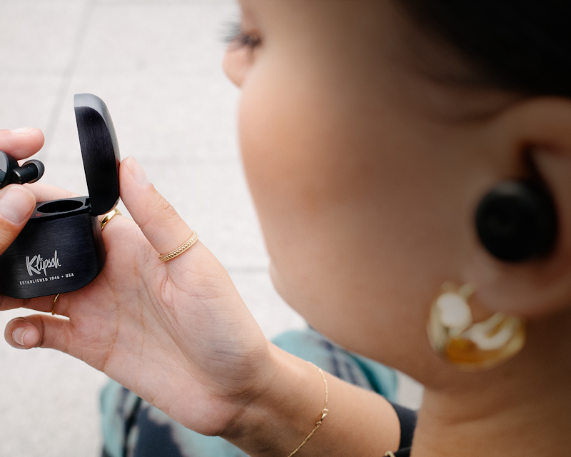 Closeup of a woman looking at her Gunmetal Klipsch T5 II True Wireless ANC Earphones Desktop
